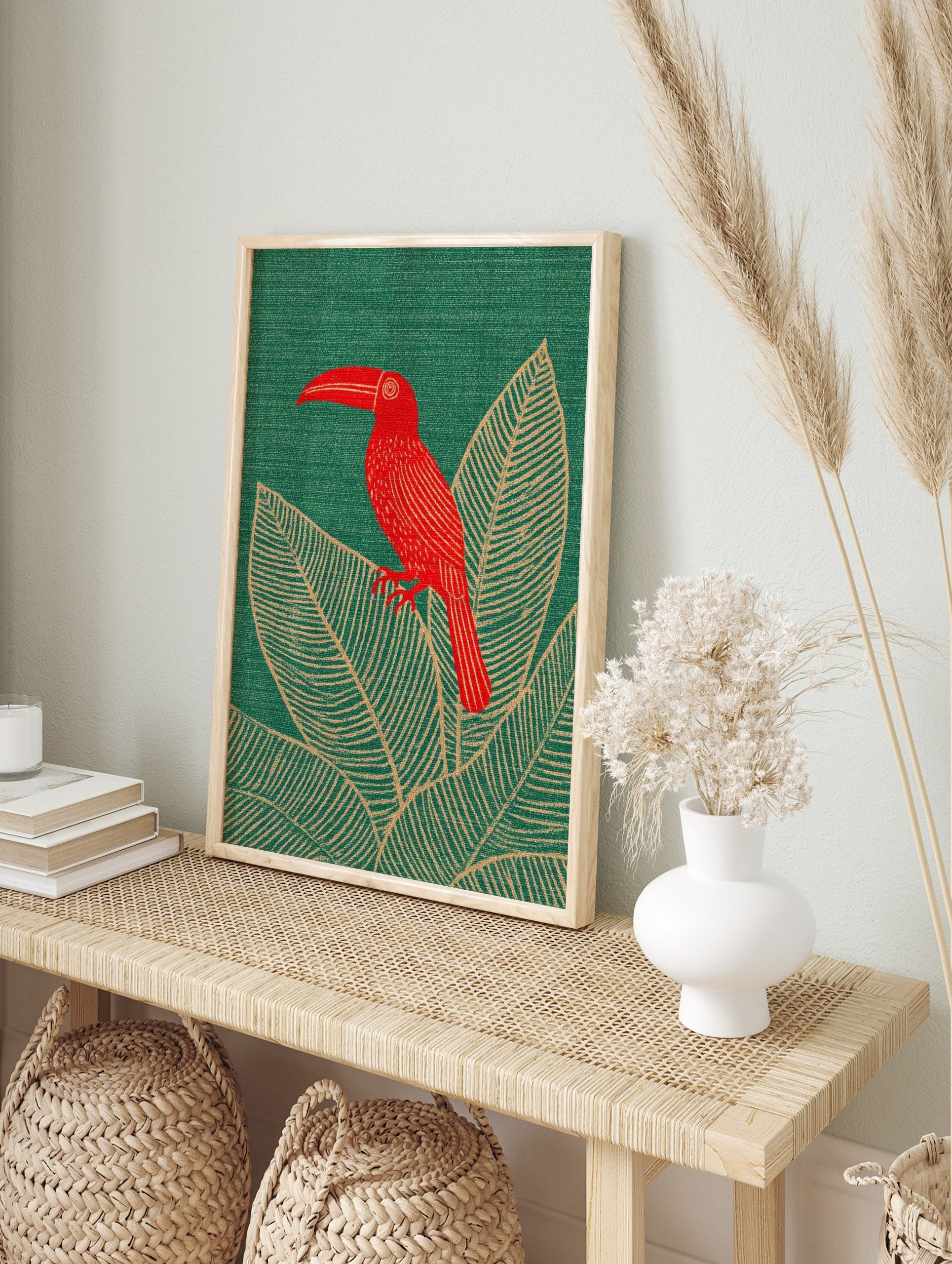 Red toucan bird with long beak perched on large tropical leaves on a green background, in an alternate framed mockup