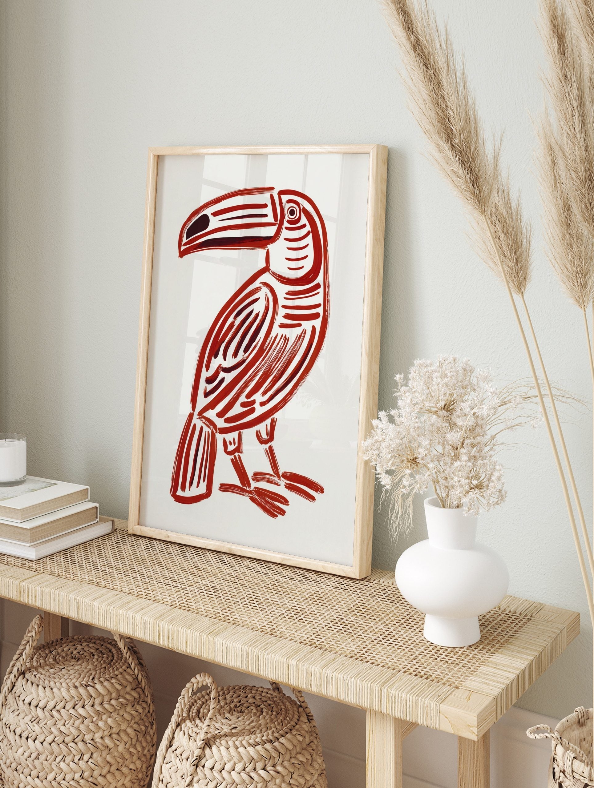 Red toucan illustration print with bold brushstrokes and dark accents on a white background, in an alternate framed mockup