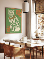 Illustrative retro cat wall art print with green stripes, orange flower lei, and green background, in a styled room mockup