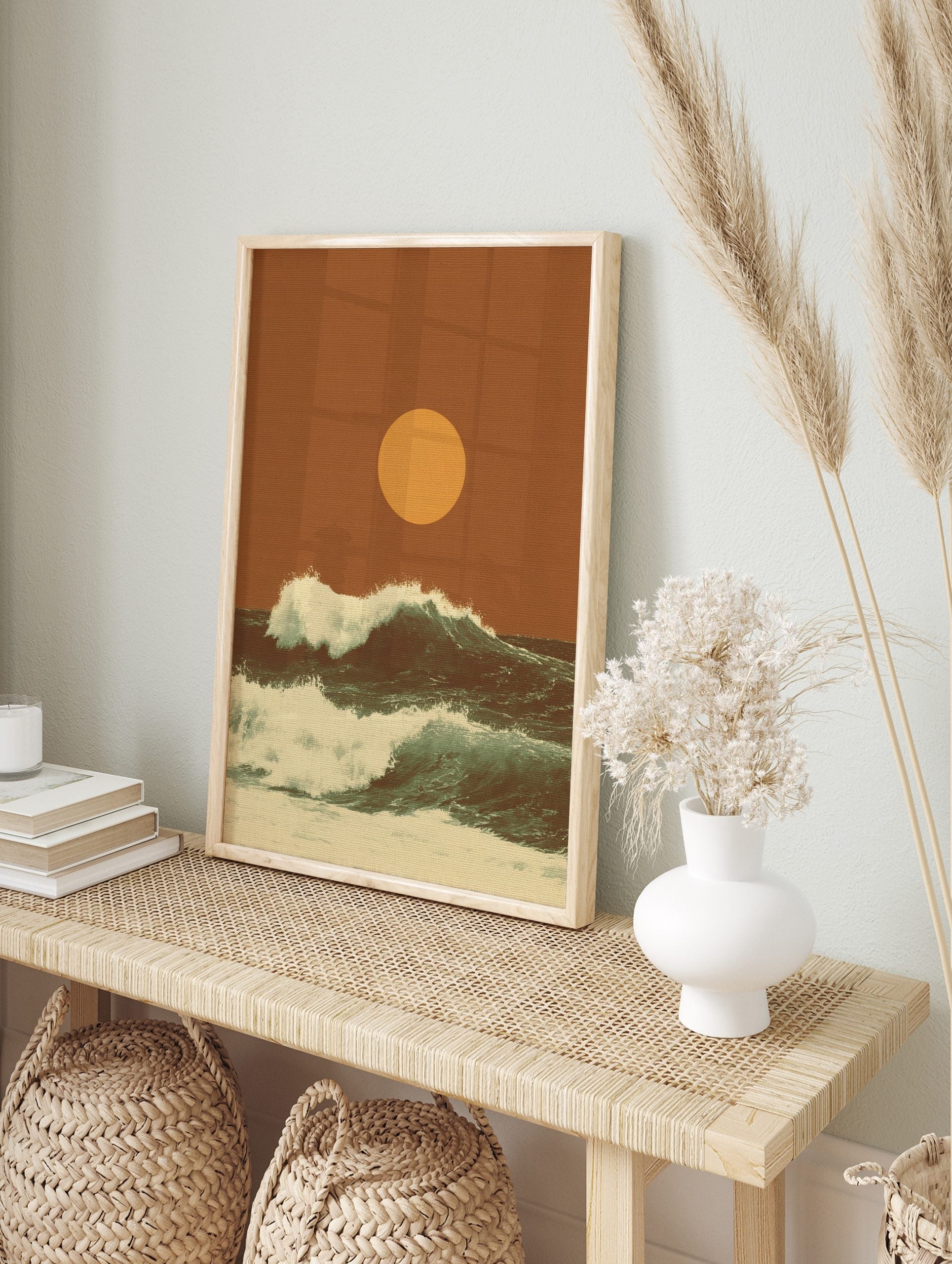 Retro ocean waves crashing with white foam under a large golden sun on an earthy orange, in an alternate framed mockup