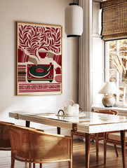 Retro illustrative print of a record player, teacup, and teapot surrounded by botanical leaves in, in a styled room mockup