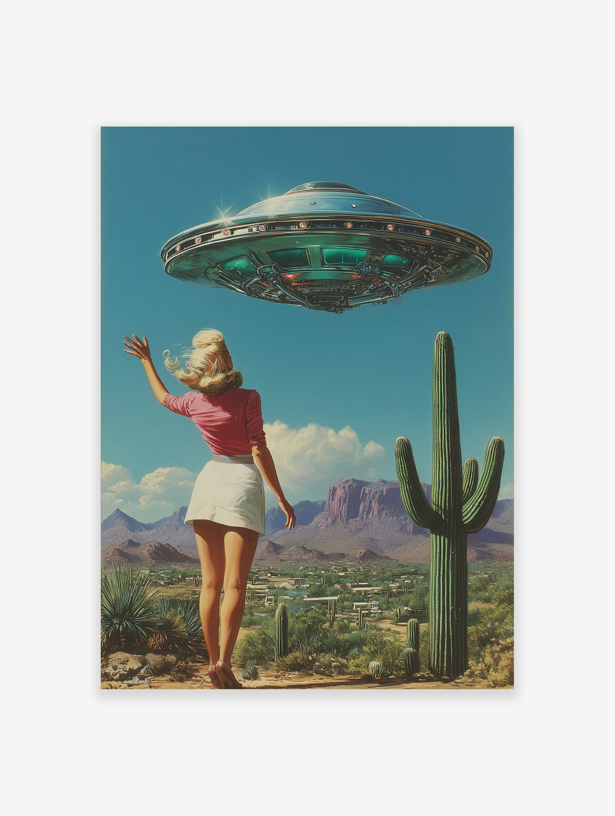 Retro UFO desert wall art featuring a woman waving at a flying saucer above a landscape with cacti and mountains