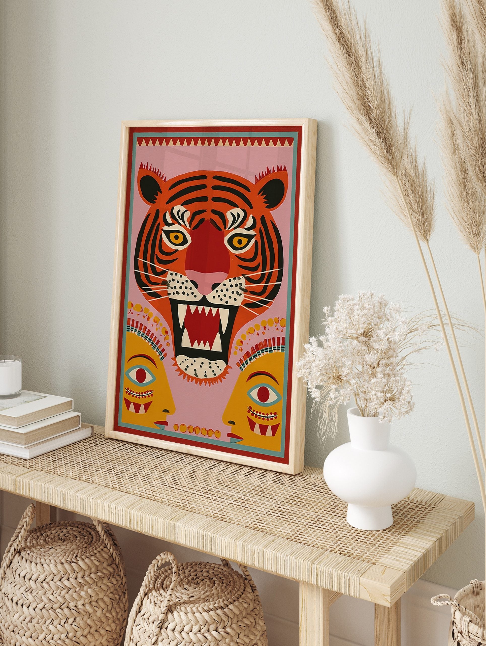 Roaring tiger head folk art print with black stripes, yellow eyes, red mouth, pink, in an alternate framed mockup