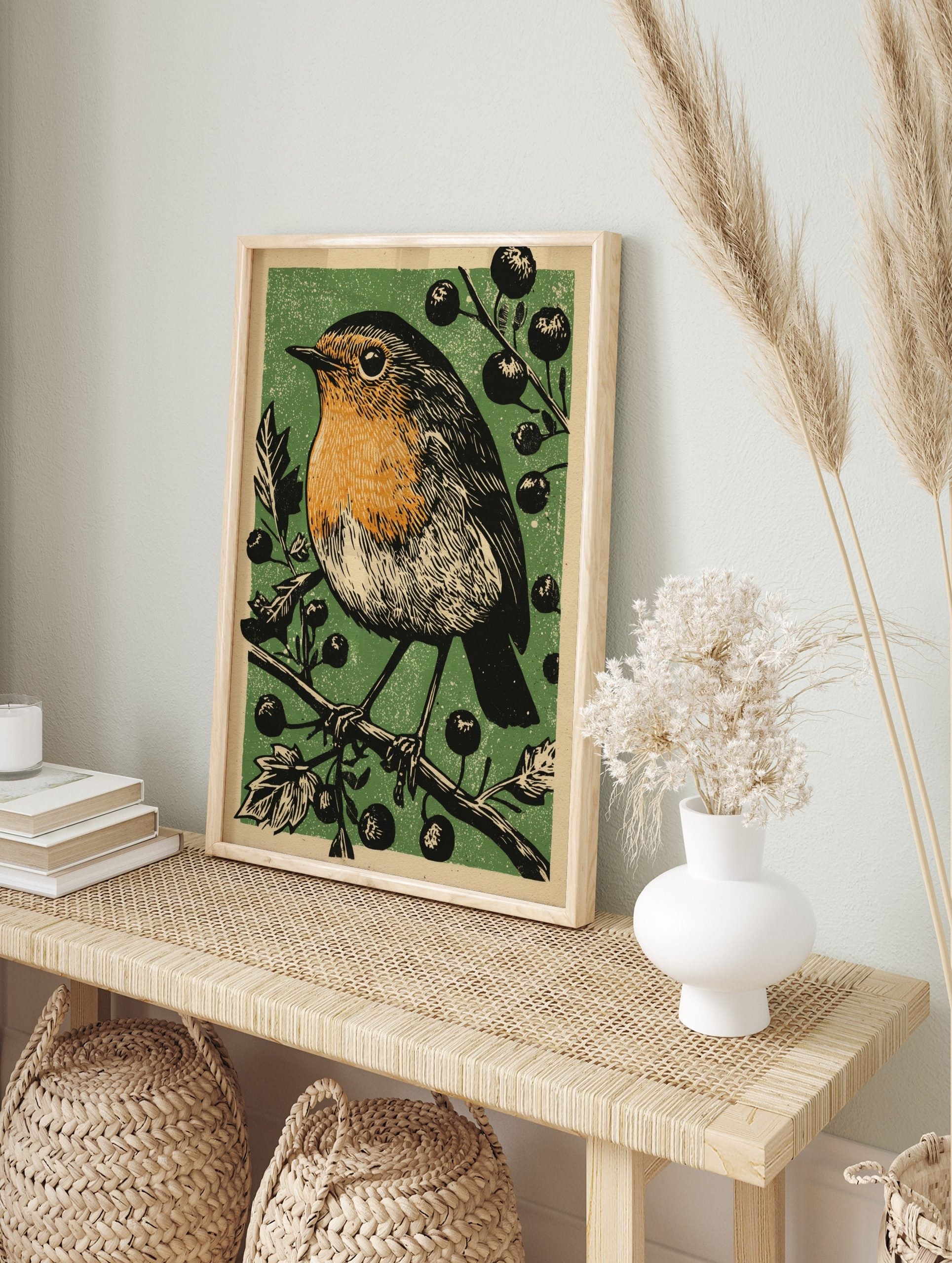 Linocut style illustration of a robin bird with orange breast on a berry branch, green, in an alternate framed mockup
