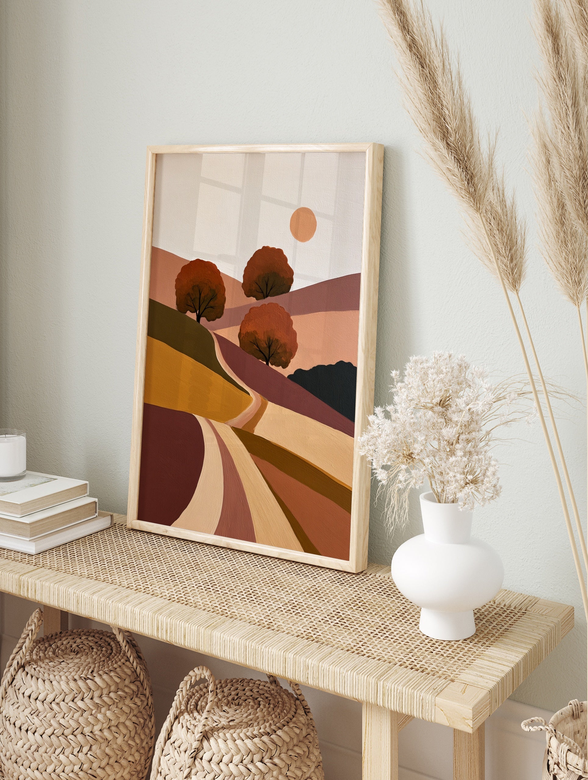 Minimalist landscape art print with rolling hills, three stylized trees, and a sun in earthy, in an alternate framed mockup
