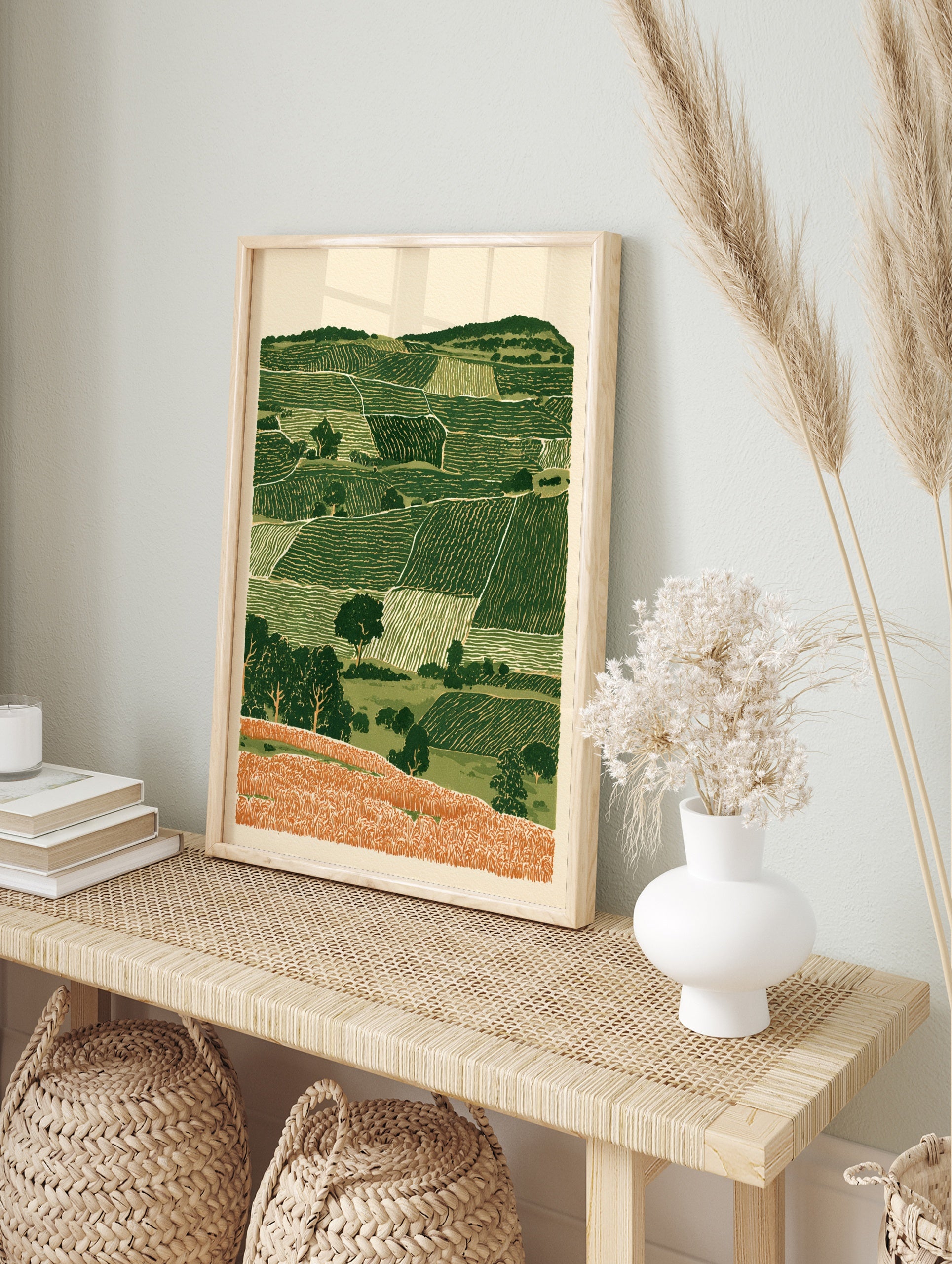 Rolling hills landscape wall art with layered green fields and orange foreground in an, in an alternate framed mockup