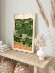 Rolling hills landscape wall art with layered green fields and orange foreground in an, in an alternate framed mockup