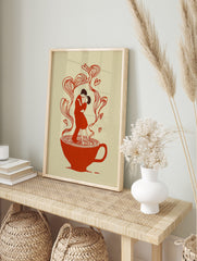 Illustrative art print of a couple dancing in a red teacup, with heart-shaped steam rising, in an alternate framed mockup