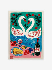 Illustrative print of two white swans forming a heart on teal water, with a picnic spread of wine, cake, and fruit