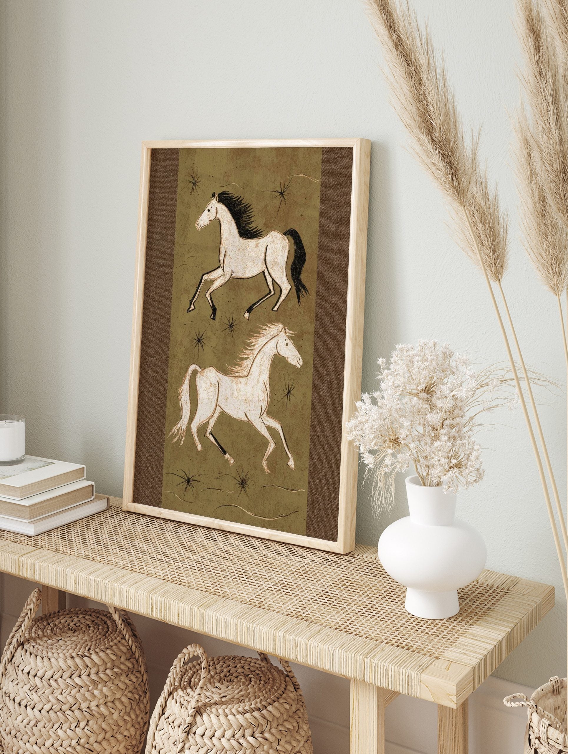 Illustrative art print of two running horses in off-white on an olive green background with, in an alternate framed mockup