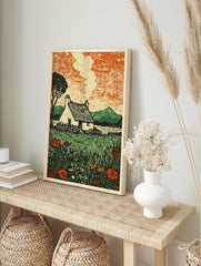 Illustrative print of a rural cottage with thatched roof, smoke, lake, mountains, and, in an alternate framed mockup