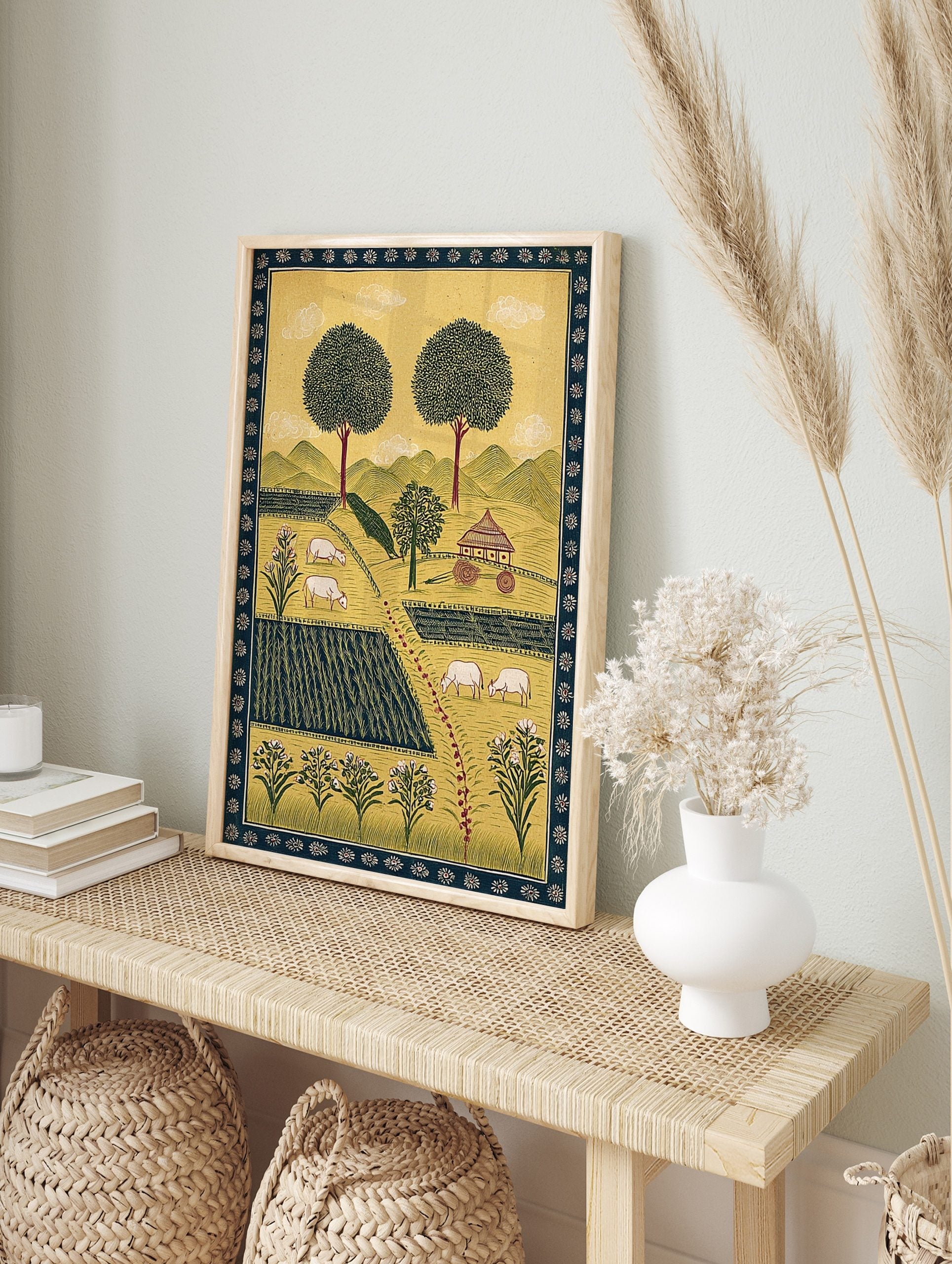 Illustrative rural farm landscape art print with green fields, white sheep, large trees, and, in an alternate framed mockup