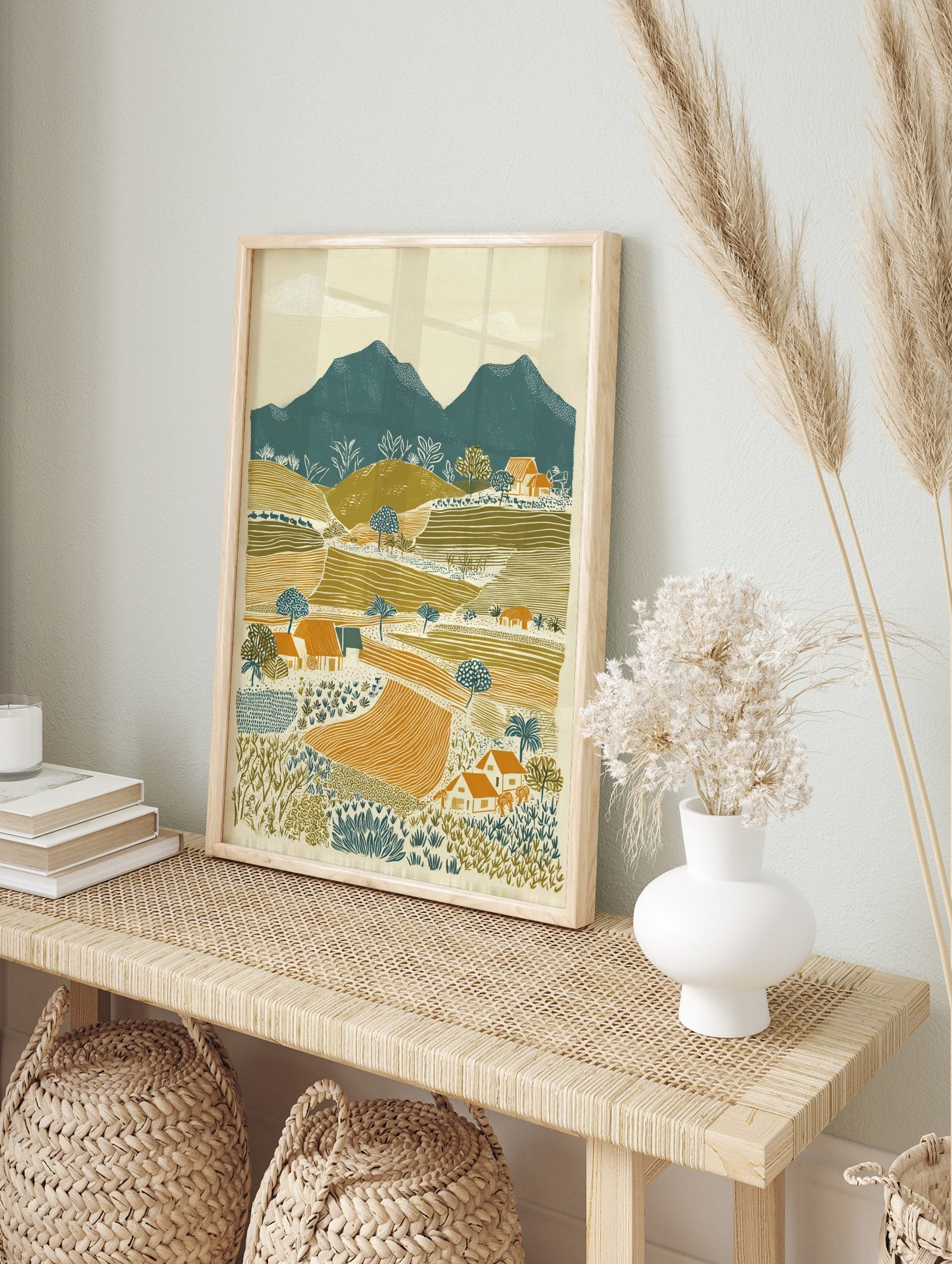 Illustrative rural landscape print with teal mountains, olive green hills, orange fields, and, in an alternate framed mockup