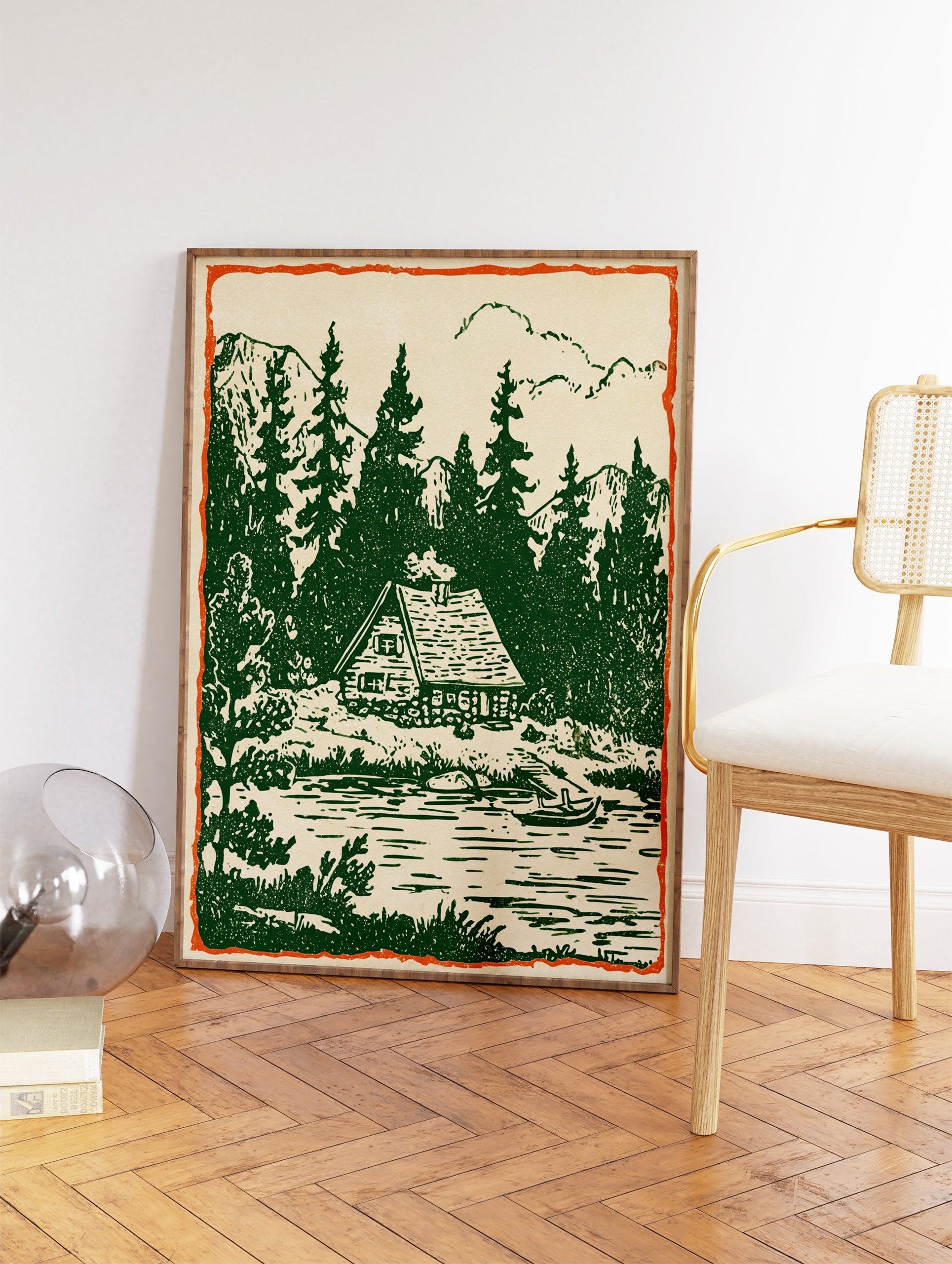 Rustic cabin wall art print showing a vintage illustration of a cabin by a forest lake with pine trees and mountains. - Image 2