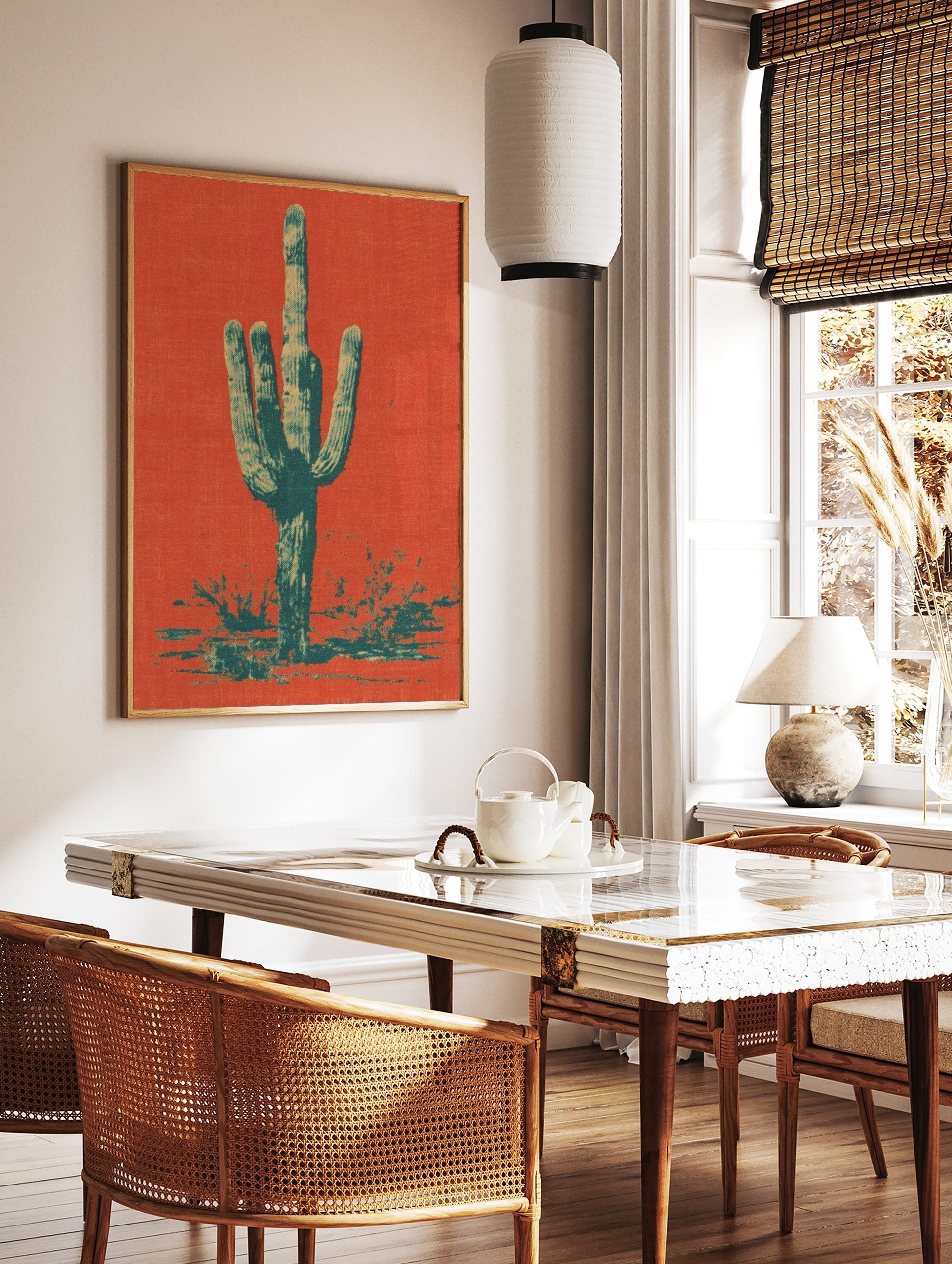 Saguaro cactus art print in orange-red and teal halftone style, with desert foliage at the base, in a styled room mockup