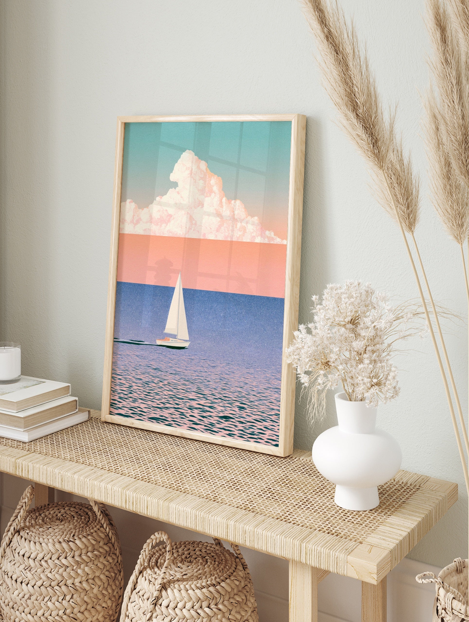 Minimalist sailboat wall art with soft pastel sky, blue water, and large cloud illustration, in an alternate framed mockup