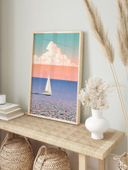 Minimalist sailboat wall art with soft pastel sky, blue water, and large cloud illustration, in an alternate framed mockup