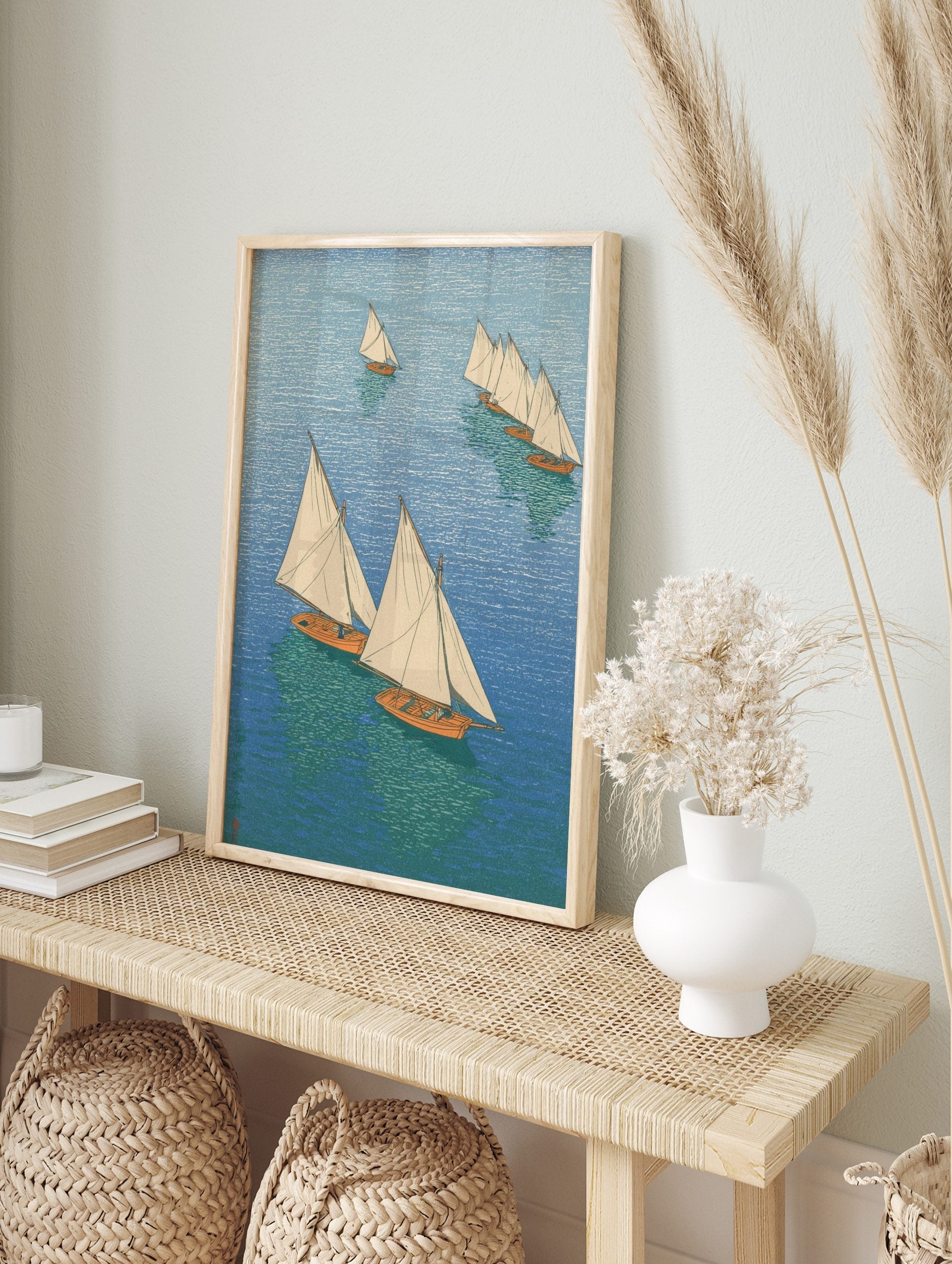 Overhead view of multiple sailboats with white sails and orange hulls on blue and green, in an alternate framed mockup
