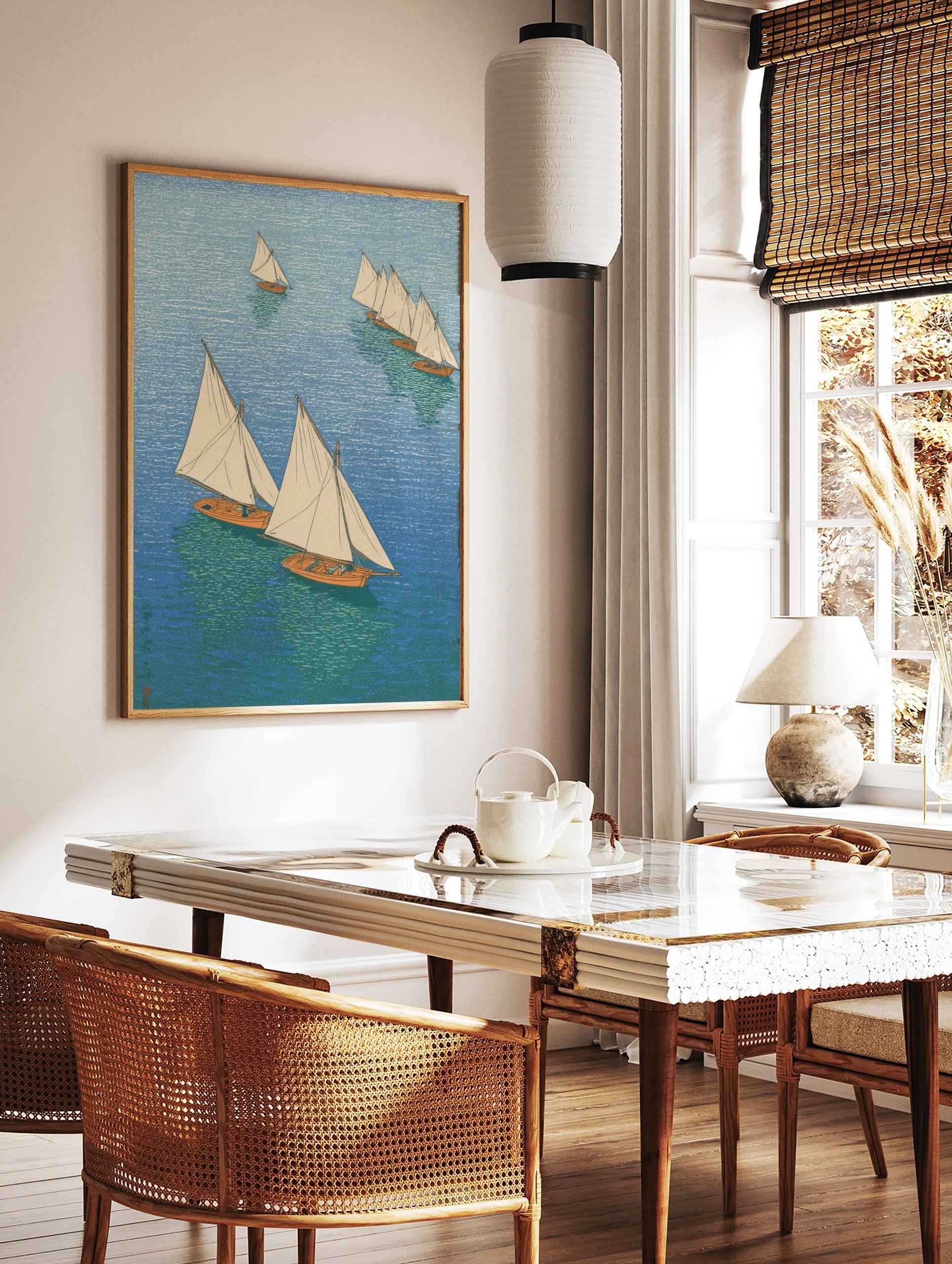 Overhead view of multiple sailboats with white sails and orange hulls on blue and green water, in a, in a styled room mockup