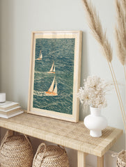 Illustrative sailboat wall art with three boats on a textured blue sea, cream sails, nautical, in an alternate framed mockup