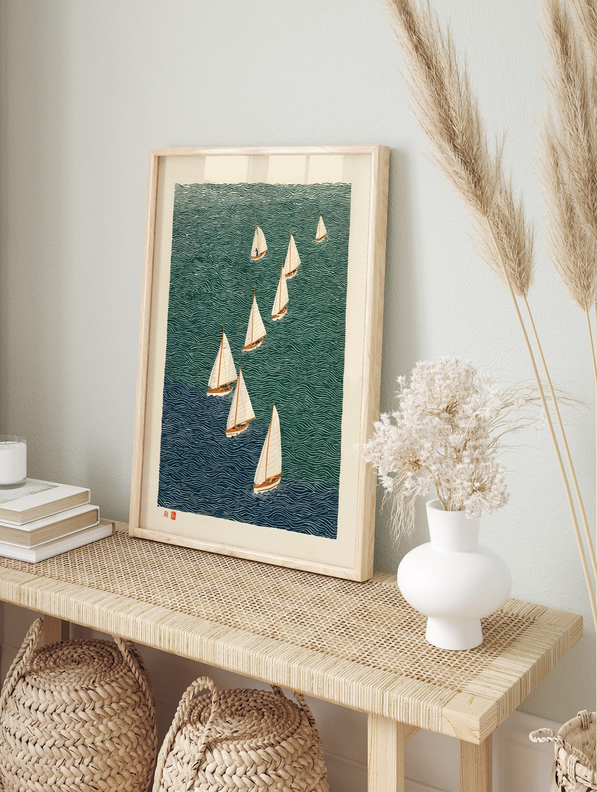 Illustrative woodcut print of nine sailboats with white sails on wavy teal and blue water, in an alternate framed mockup