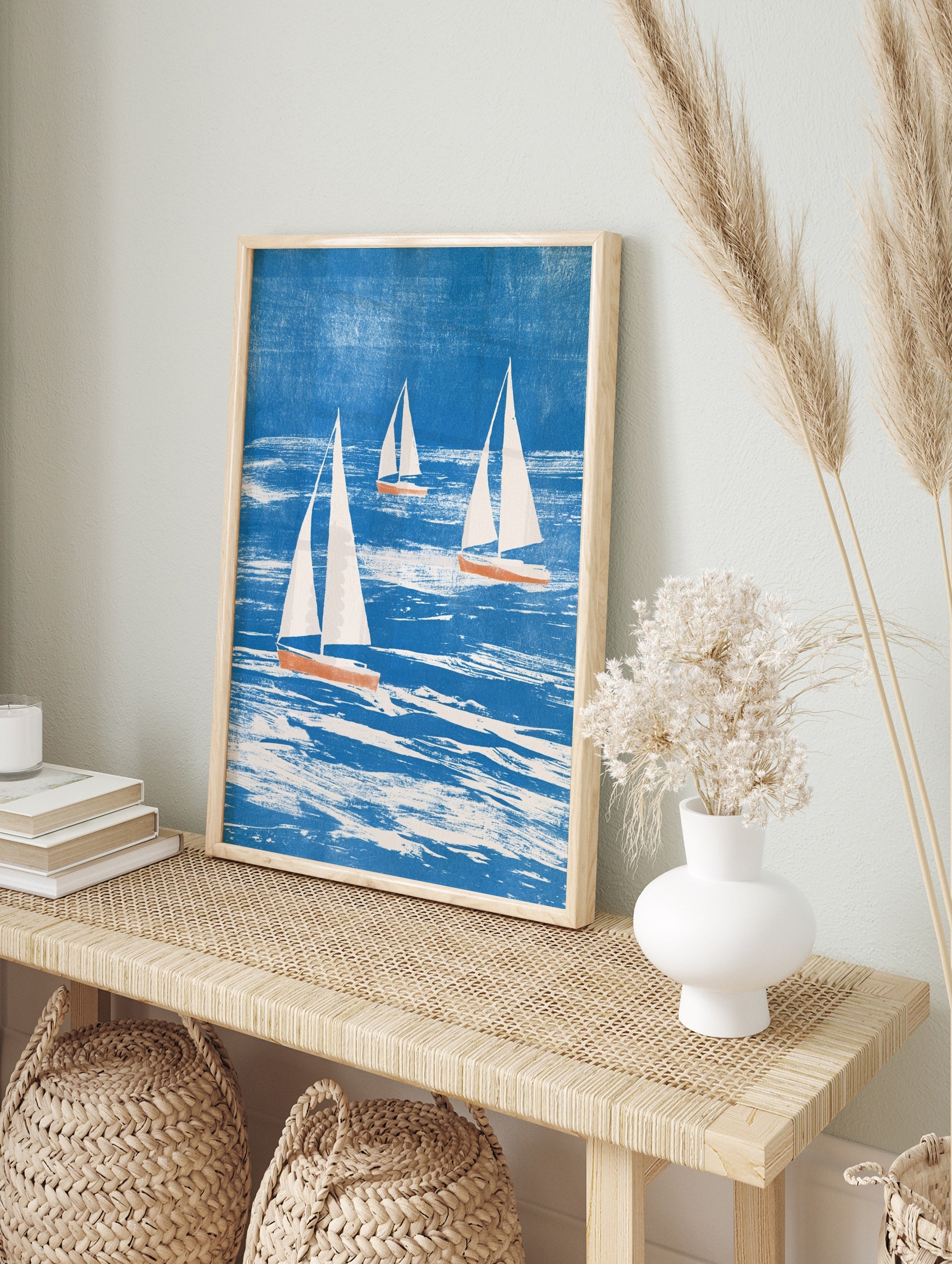 Three sailboats with white sails and coral hulls on a textured blue sea, illustrative, in an alternate framed mockup