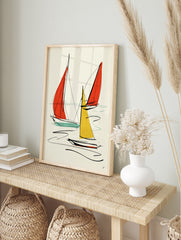 Minimalist sailboat wall art with red and yellow sails and black ink lines on a neutral, in an alternate framed mockup