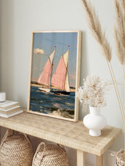 Painterly art print of two sailboats with pink sails on blue water, coastal nautical scene, in an alternate framed mockup