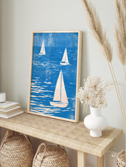 Three sailboats on textured blue water, illustrative style nautical wall art print with cream, in an alternate framed mockup