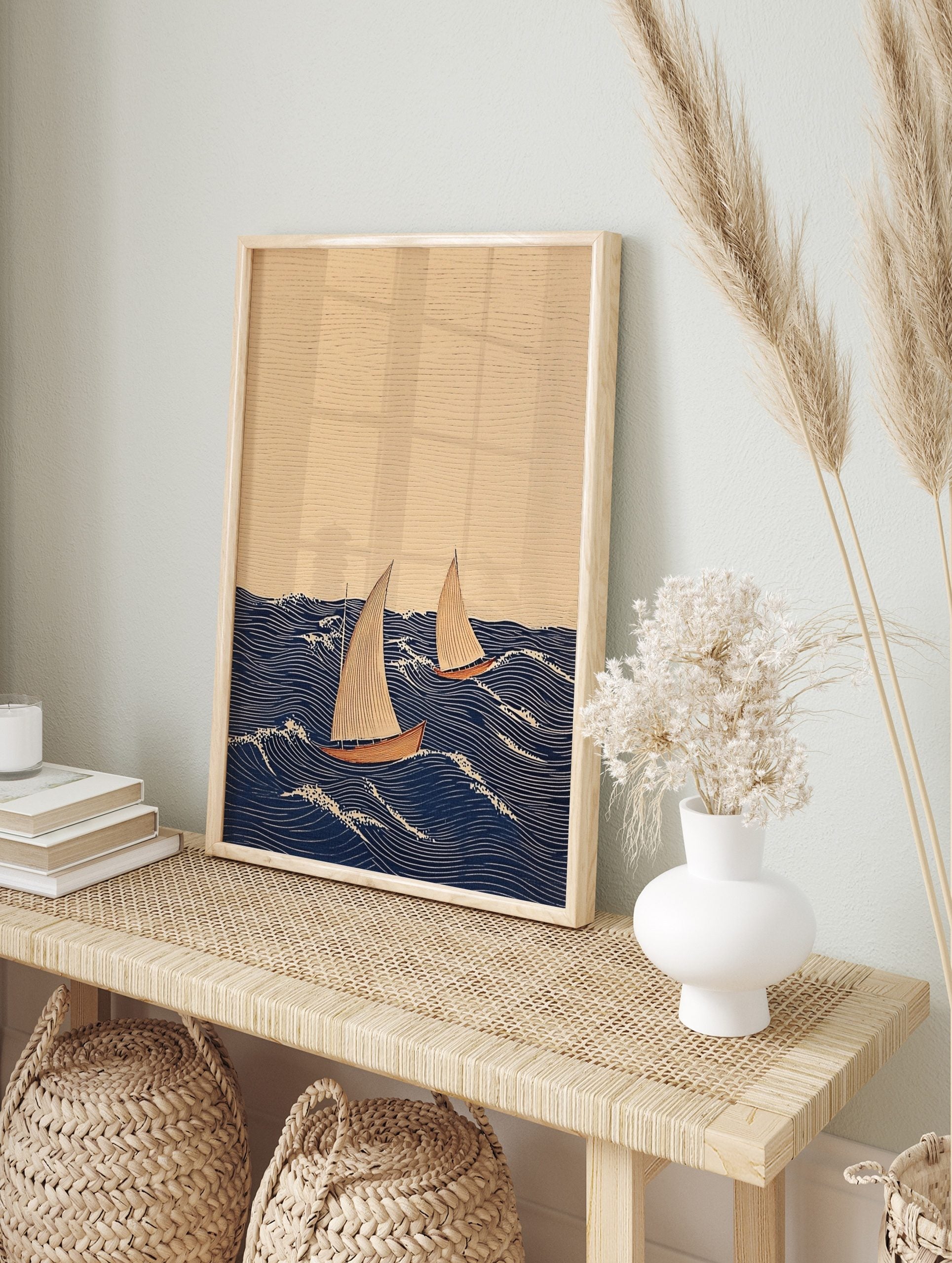 Illustrative print of two sailboats with beige sails and reddish hulls on a dark blue wavy, in an alternate framed mockup