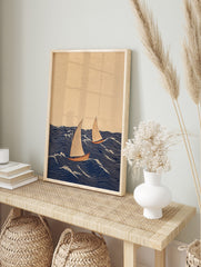 Illustrative print of two sailboats with beige sails and reddish hulls on a dark blue wavy, in an alternate framed mockup