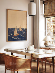 Illustrative print of two sailboats with beige sails and reddish hulls on a dark blue wavy sea with, in a styled room mockup