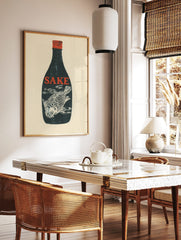 Dark blue sake bottle with red 'SAKE' text and white fish illustration inside, red cap, cream, in a styled room mockup