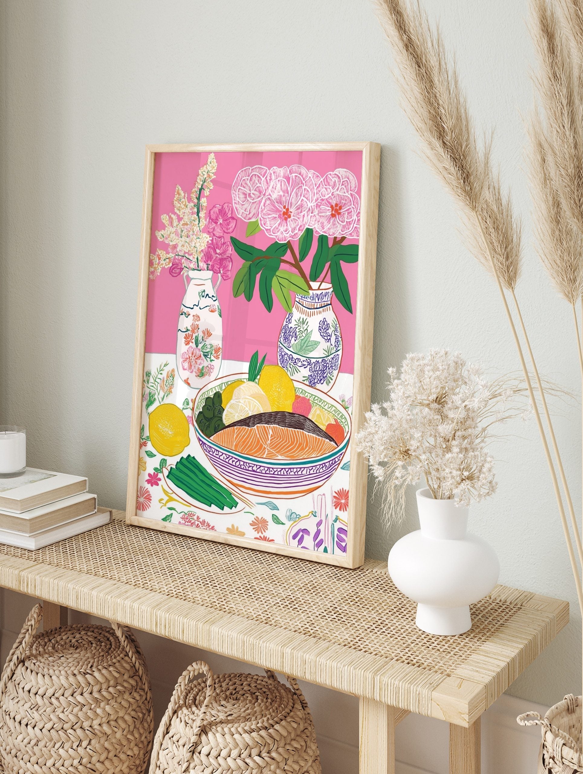 Colourful still life illustration of salmon, lemons, olives, asparagus, and pink flowers in, in an alternate framed mockup