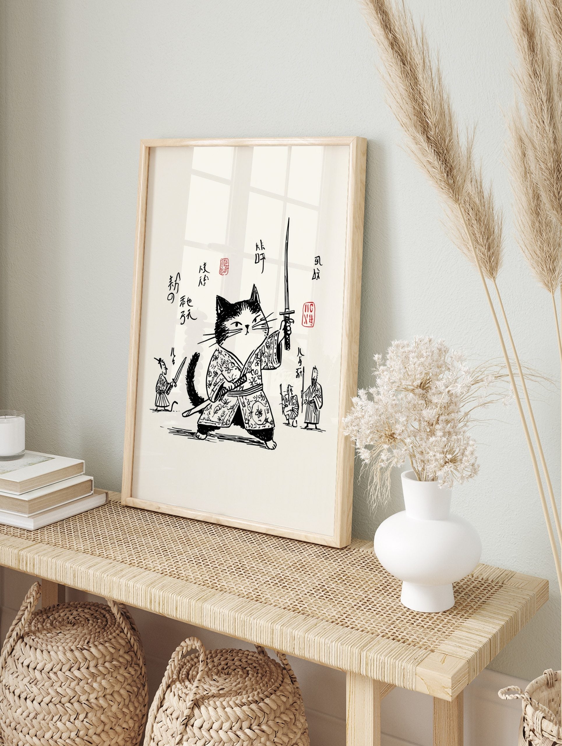Monochrome illustrative print of a samurai cat in traditional Japanese attire, holding a, in an alternate framed mockup