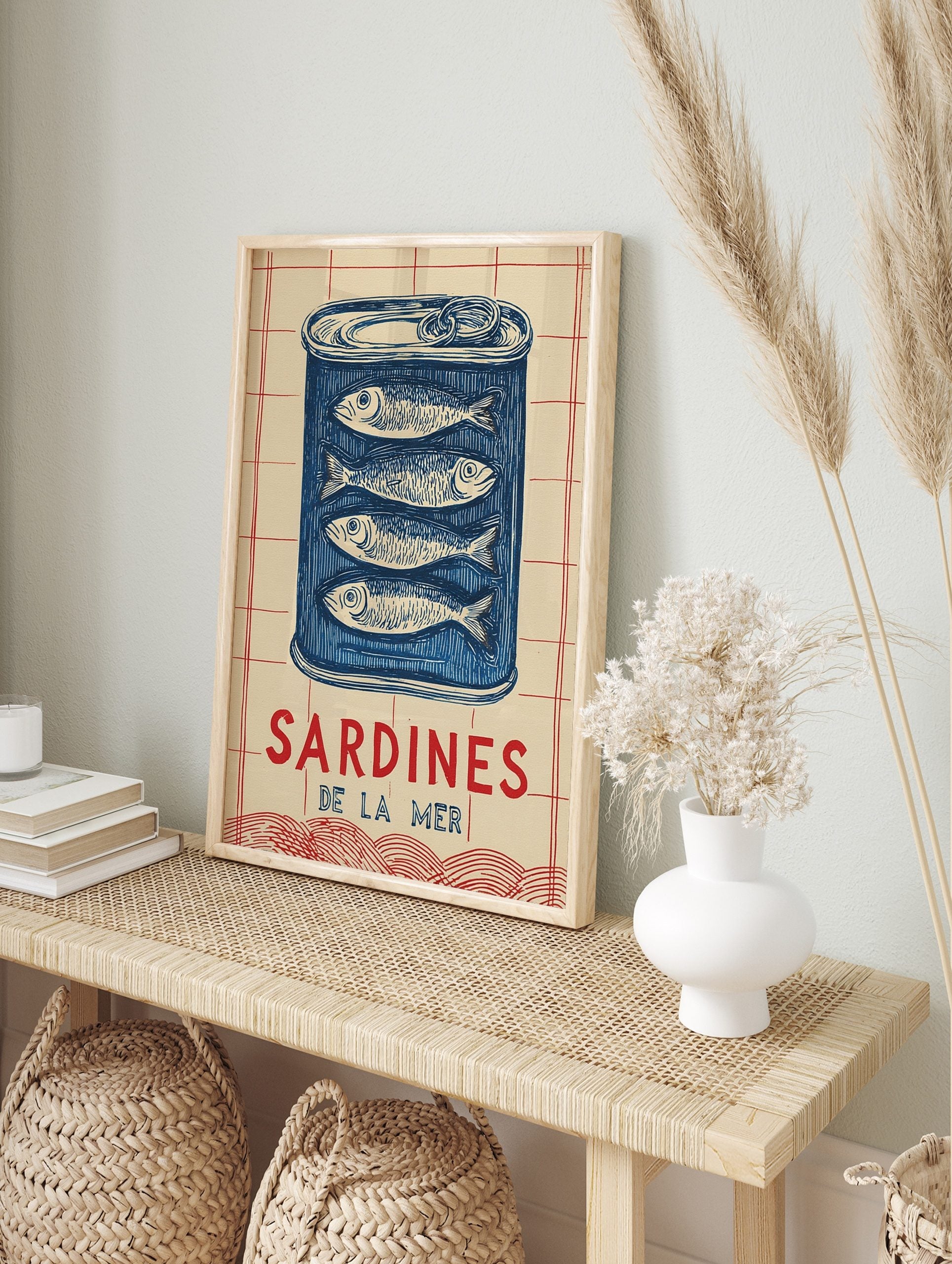 Illustrative blue sardine tin wall art with four fish and 'SARDINES DE LA MER' text on a, in an alternate framed mockup
