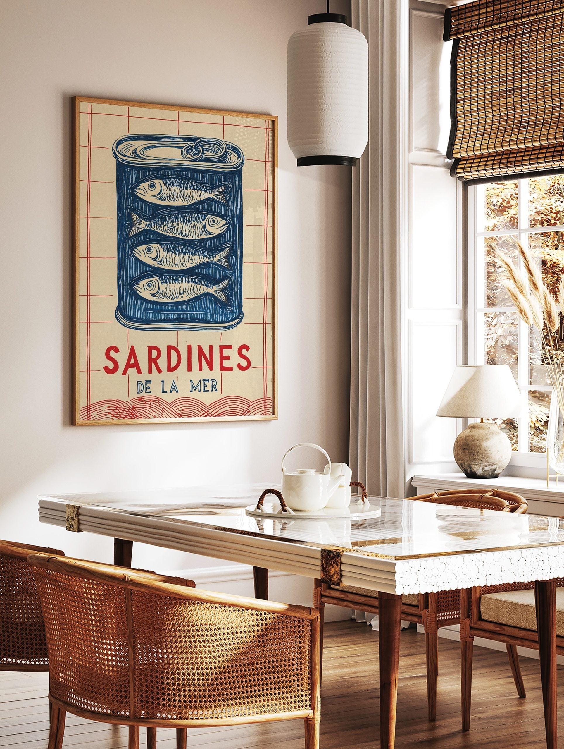 Illustrative blue sardine tin wall art with four fish and 'SARDINES DE LA MER' text on a cream and, in a styled room mockup