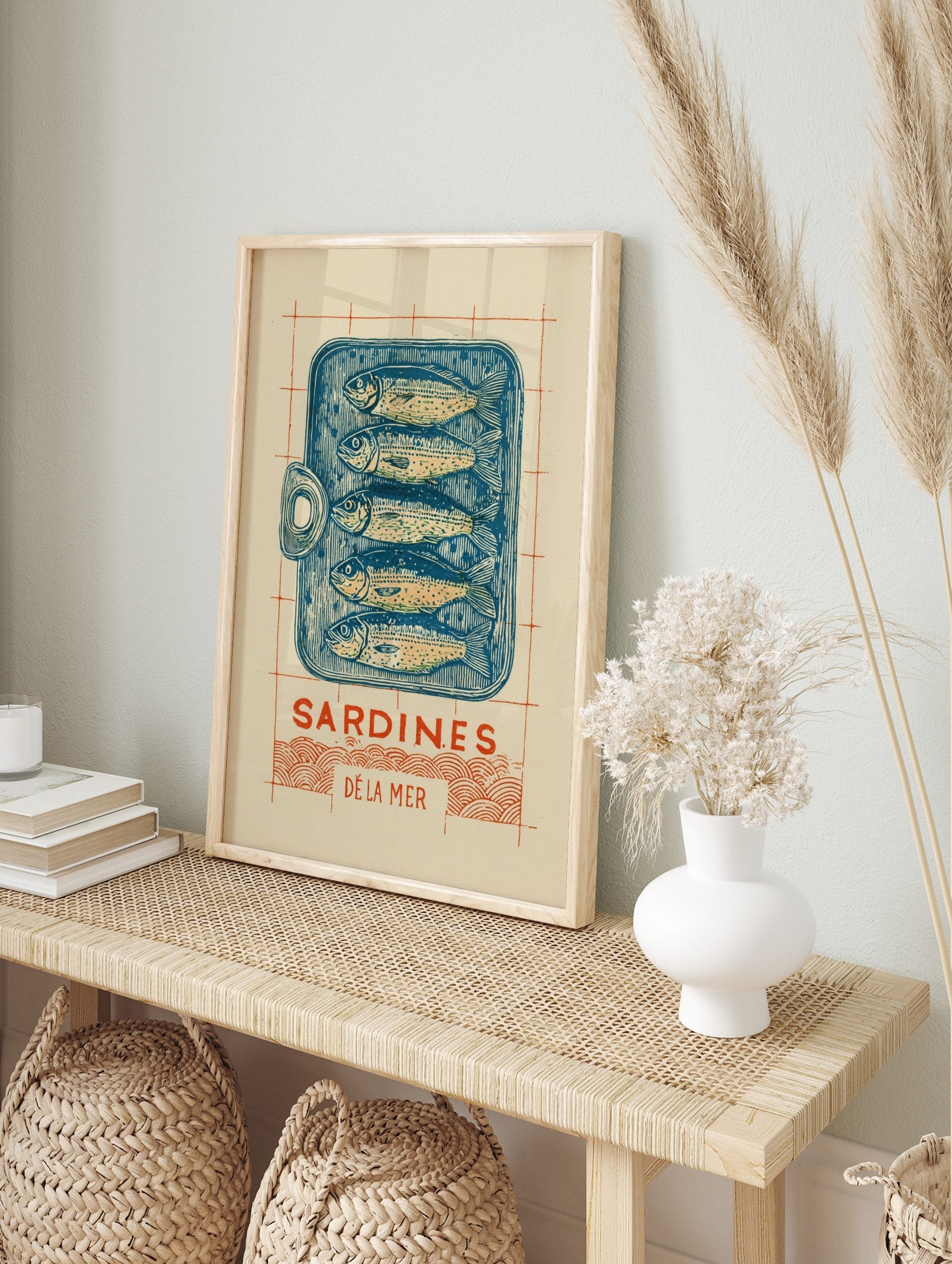Illustrative linocut-style print of a blue sardine tin with five fish, 'Sardines Dé La Mer', in an alternate framed mockup