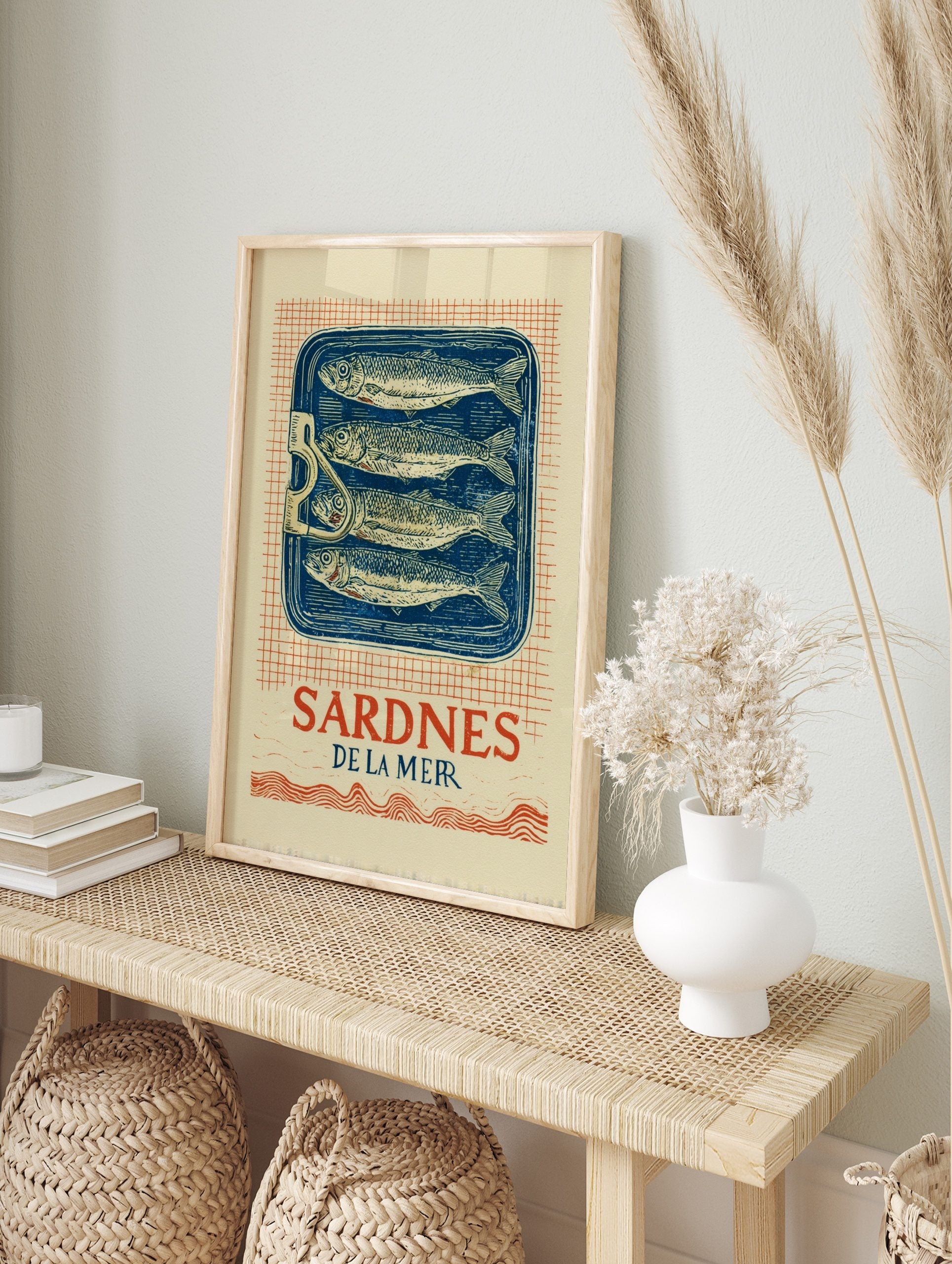 Vintage Sardines De La Mer wall art print with four fish in a blue tin, red grid background, in an alternate framed mockup