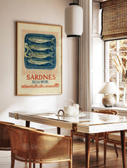 Vintage Sardines De La Mer wall art print with four fish in a blue tin, red grid background, and, in a styled room mockup