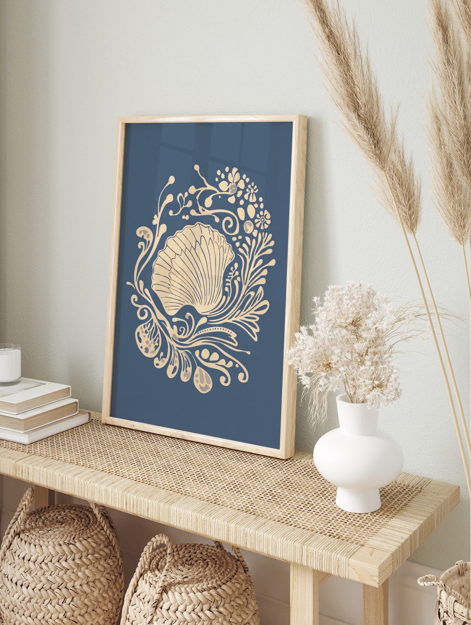 Ornate scallop shell illustration with beige botanical swirls on a deep blue background, in an alternate framed mockup