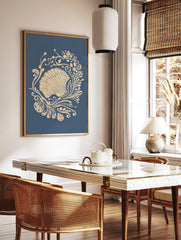 Ornate scallop shell illustration with beige botanical swirls on a deep blue background, in a styled room mockup