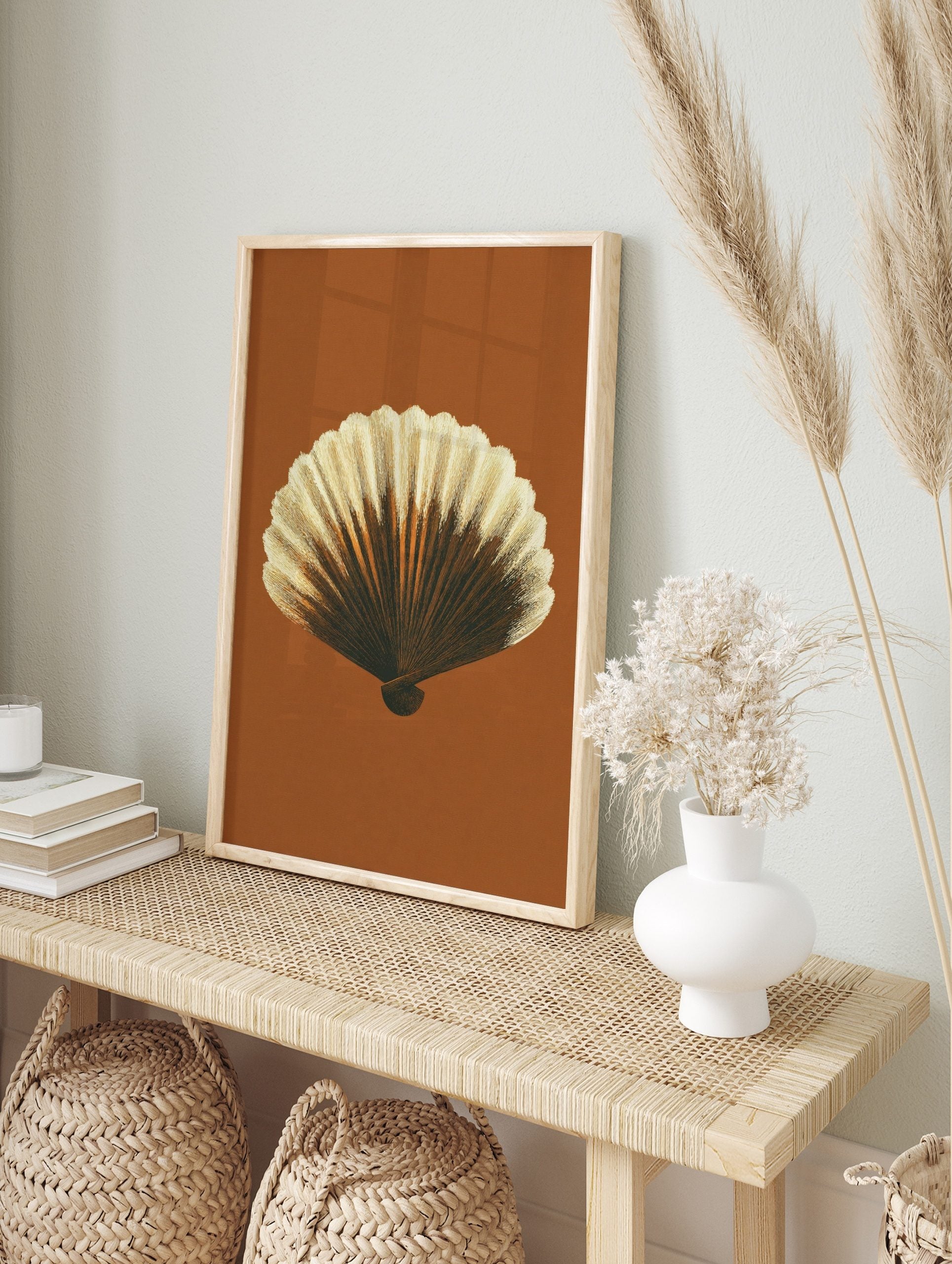 Detailed illustrative print of a scallop shell in brown and cream tones against a rust, in an alternate framed mockup