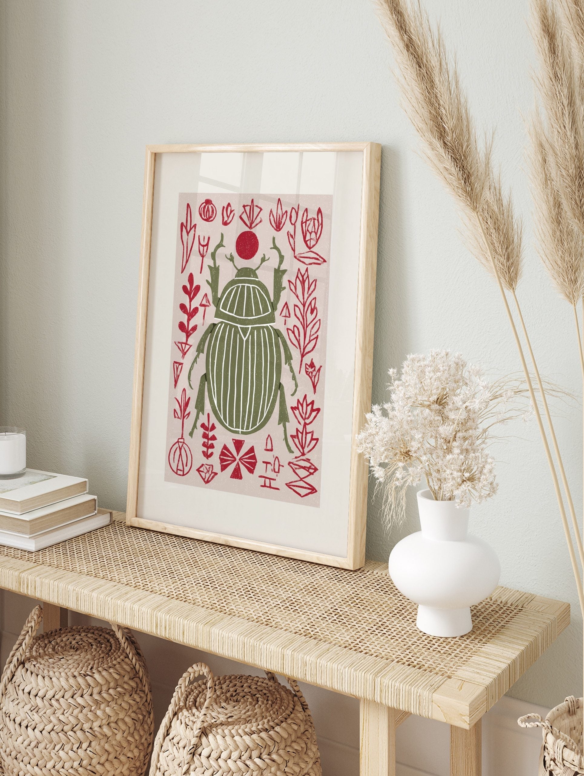 Olive green scarab beetle print with white stripes, surrounded by red abstract botanical, in an alternate framed mockup