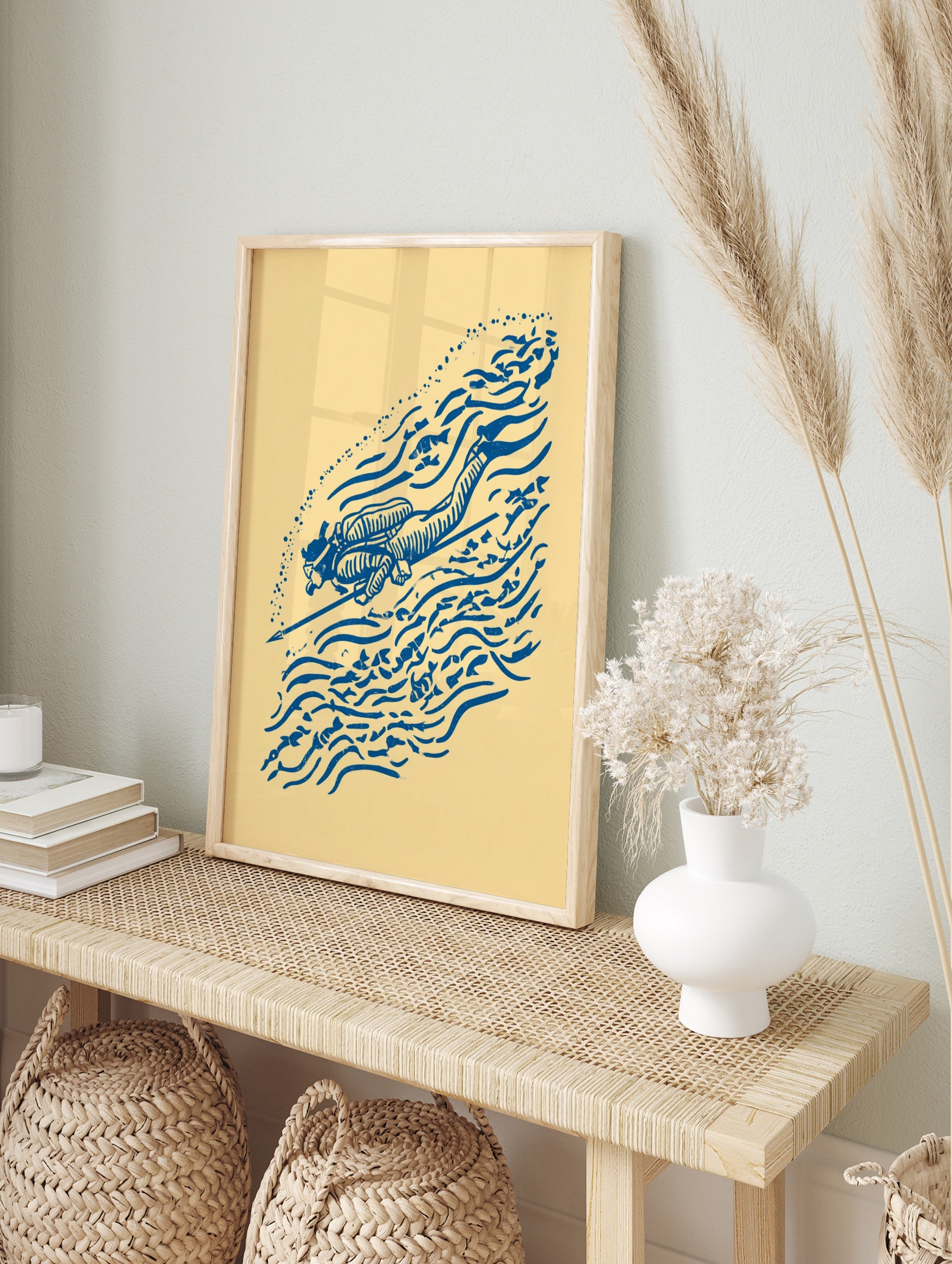 Blue illustrative scuba diver print with speargun, fish, and bubble motifs on a cream, in an alternate framed mockup