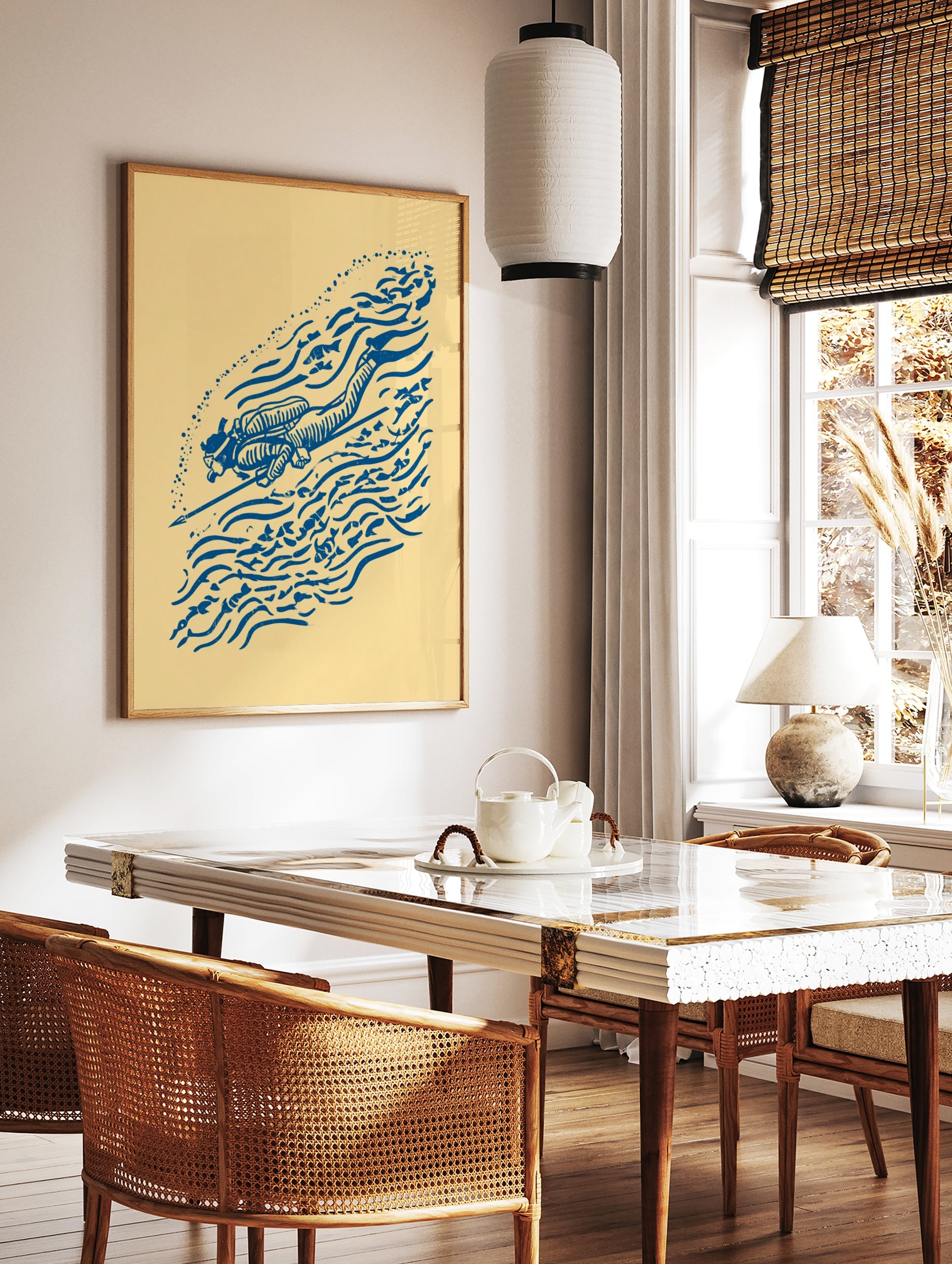 Blue illustrative scuba diver print with speargun, fish, and bubble motifs on a cream background, in a styled room mockup