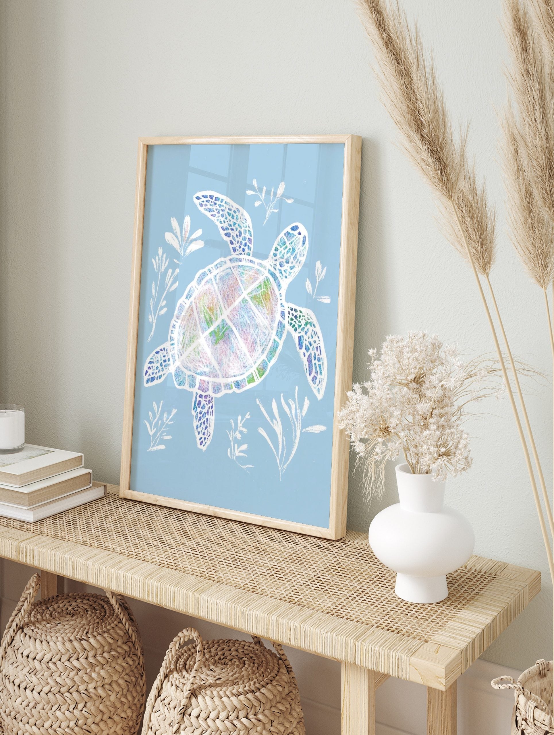 Colourful sea turtle illustration with white outlines, swimming with white seaweed on a pale, in an alternate framed mockup