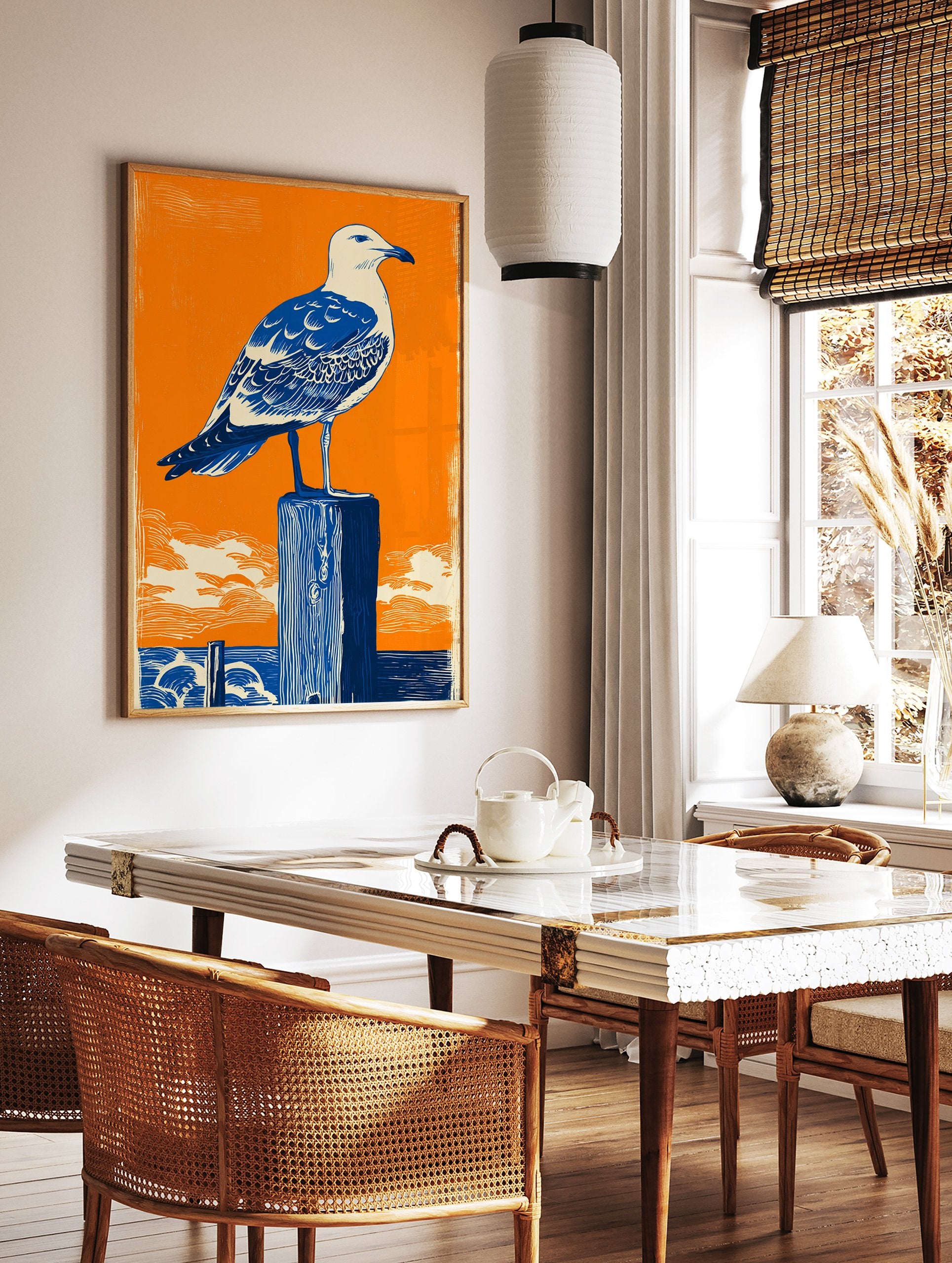 Seagull Wall Art linocut print featuring a blue and white seagull on a dark blue wooden post against an orange sky and ocean. - Image 3