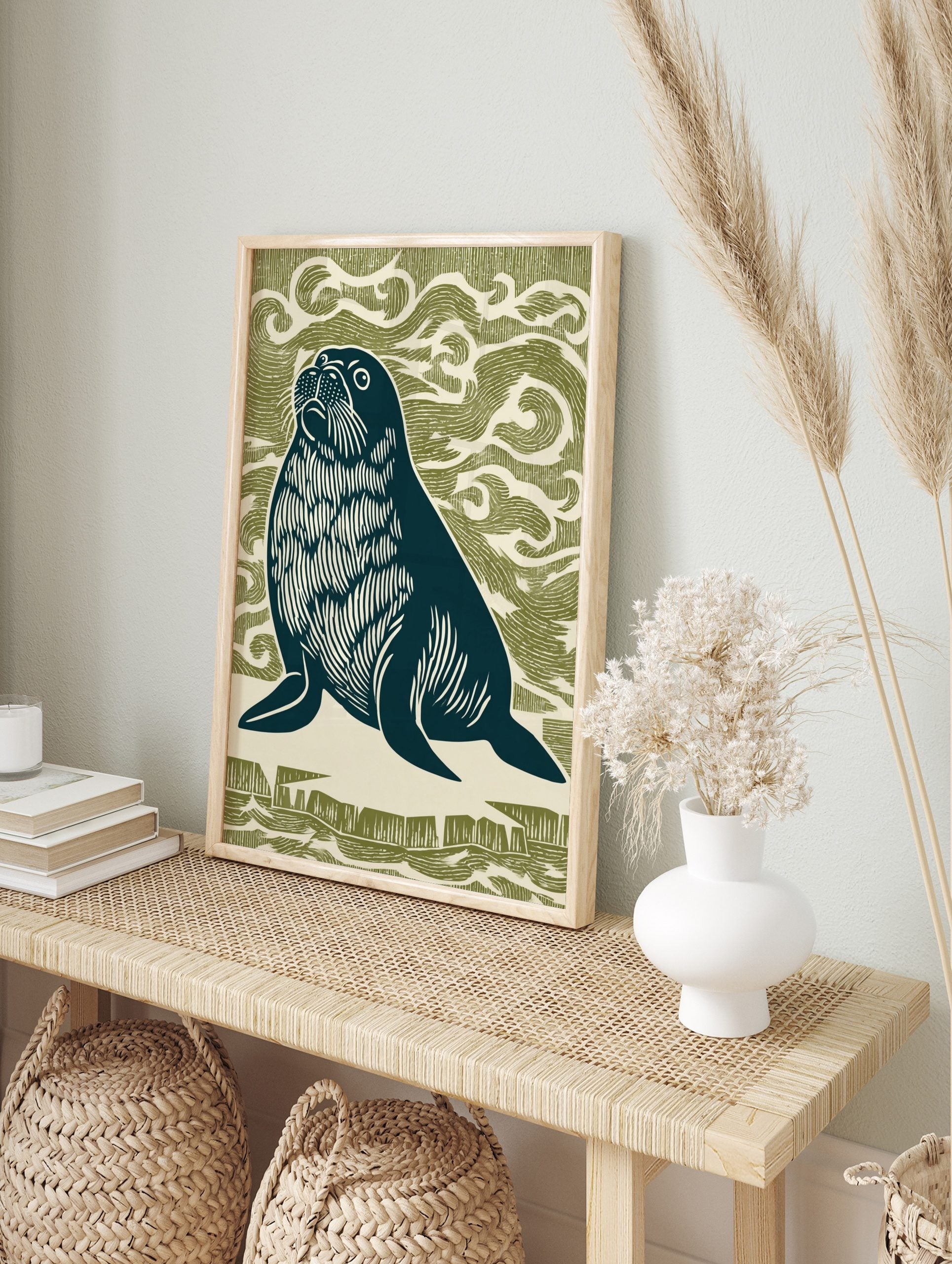 Linocut style seal looking up, dark navy with white details, against an olive green wavy, in an alternate framed mockup