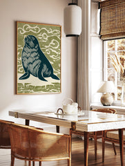Linocut style seal looking up, dark navy with white details, against an olive green wavy background, in a styled room mockup